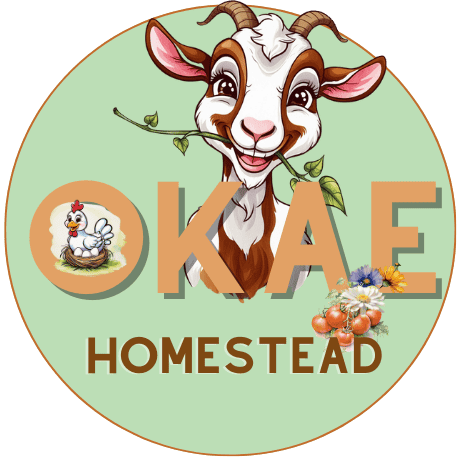 Letters O, K, A, E in front of a cartoon goat with a plant in its mouth, a chicken on eggs in a nest is inside the O and the word Homestead along the bottom of logo